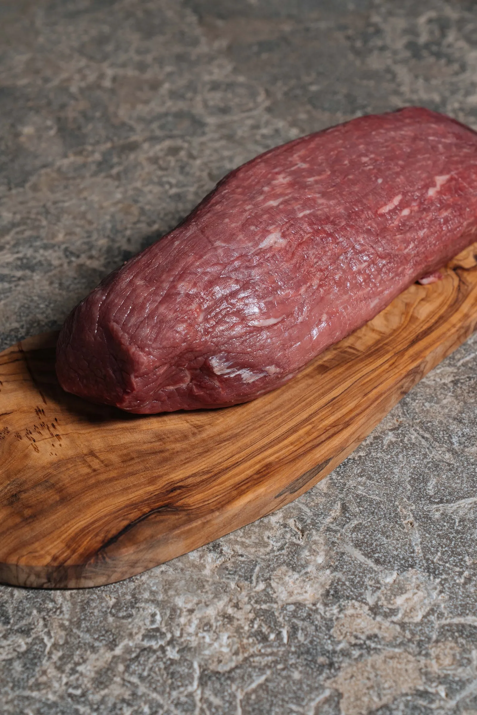 Een volledige filet van Tajiri op een plank van olijfhout